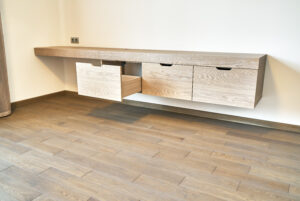Modern furniture. Wall mounted American Oak dressing table with drawers in contemporary bedroom